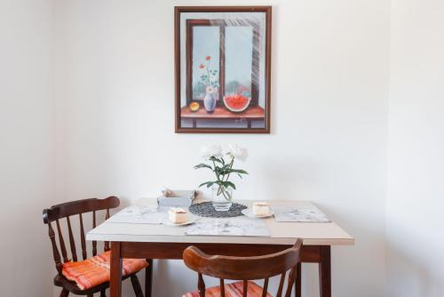 a dining room table with two chairs and a picture on the wall at DREAM Bled Apartments in Bled