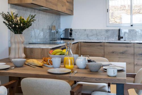 una mesa de madera con comida en la cocina en Résidence Omigna en Cargèse