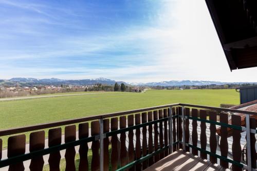 a balcony with a view of a green field at Ferienwohnung Franz in Waltenhofen