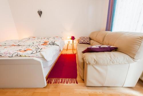 a bedroom with a bed and a couch and a red rug at DREAM Bled Apartments in Bled