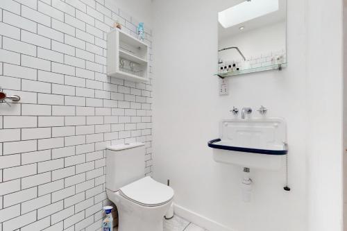 uma casa de banho branca com um lavatório e um WC em Spacious studio flat in Forest Gate em Londres