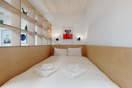 uma cama num quarto com duas toalhas brancas em Spacious studio flat in Forest Gate em Londres