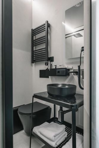 a black and white bathroom with a sink and a toilet at Ribas Rooms Lutsk in Lutsk