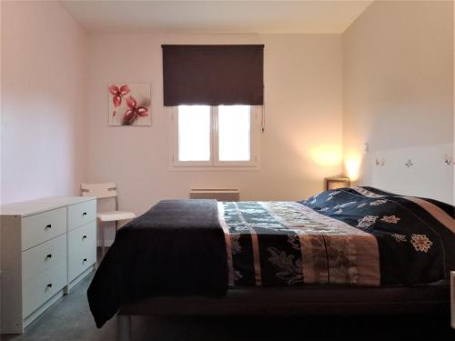 Anglade的住宿－Au petit lieu-dit，一间卧室设有一张床和一个窗口