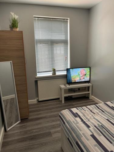 a room with a bed and a tv and a window at Grays Accommodation B&B in Grays Thurrock