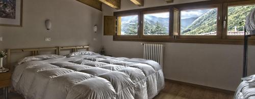 a bedroom with a large bed with a large window at Piccolo Hotel in Lizzano in Belvedere