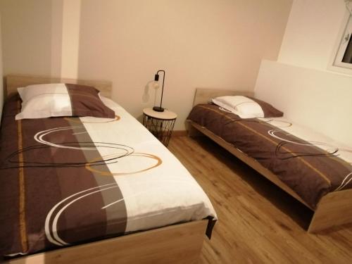 dos camas sentadas una al lado de la otra en un dormitorio en Le Tiluce, en Aunay-sur-Odon