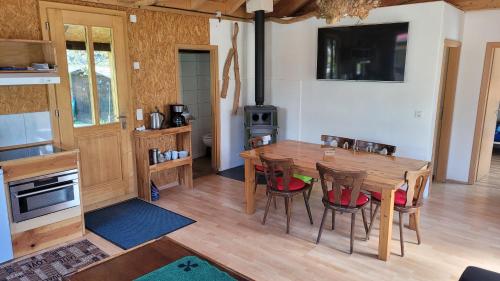 eine Küche und ein Esszimmer mit einem Holztisch und Stühlen in der Unterkunft lodge sibylle in Soubey