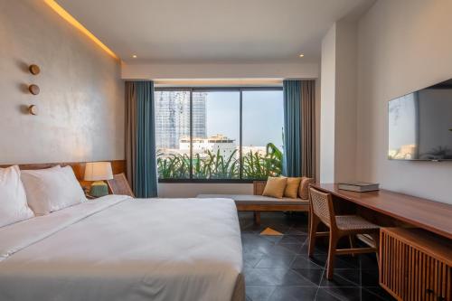 Habitación de hotel con cama grande y escritorio. en Le Mint Hotel Quy Nhơn, en Quy Nhon