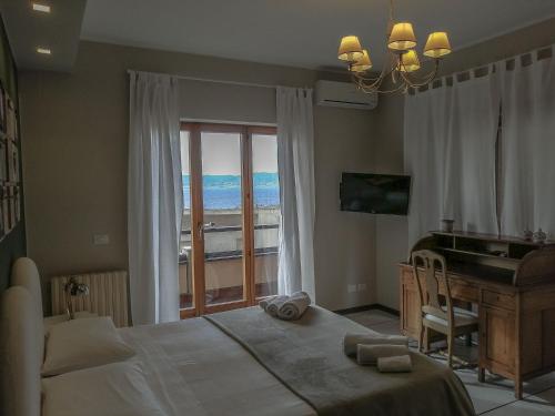 um quarto com uma cama, uma secretária e uma janela em Villa Anna em Reggio di Calabria