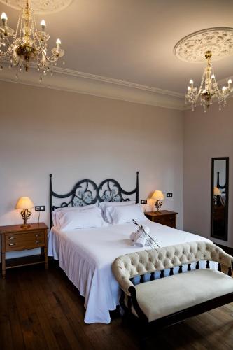 a bedroom with a large bed and two tables and a chandelier at POSADA SEMILLA in La Abadilla