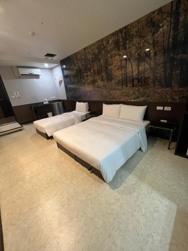 a bedroom with two beds and a painting on the wall at 苓旅萬年-LIN INN Wan Nian in Taipei