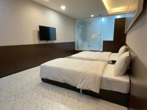 1 dormitorio con 1 cama grande y TV de pantalla plana en 苓旅萬年-LIN INN Wan Nian en Taipéi