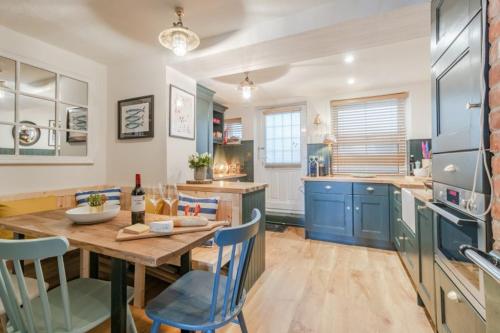 クローマーにあるBeach Houseのキッチン(木製テーブル、青いキャビネット付)