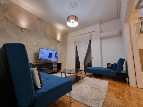 een woonkamer met een blauwe bank en een tafel bij Arman Group Arya in Athene