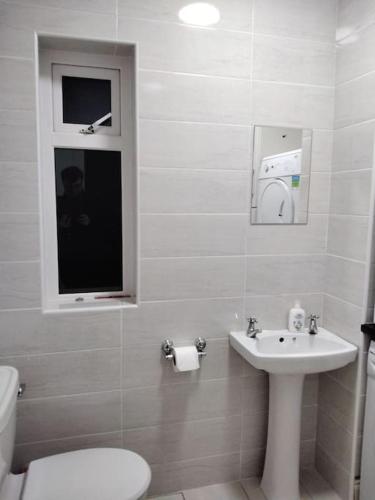 a white bathroom with a toilet and a sink at Townhouse Clifden: Located in the heart of Connemara in Clifden