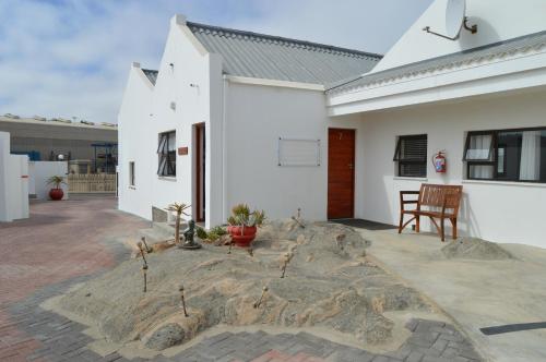 a courtyard of a white house with a rock at The Cormorant House in Lüderitz