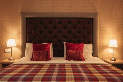 um quarto com uma cama grande e almofadas vermelhas em The Bowmore Lodge em Bowmore