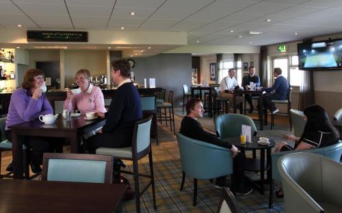 un groupe de personnes assises à table dans un restaurant dans l'établissement Hunley Golf Club, à Saltburn-by-the-Sea