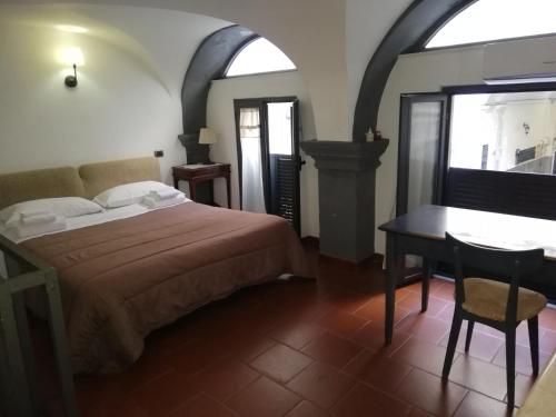 ナポリにあるNapulè Apartmentのベッドルーム1室(ベッド1台、テーブル、窓付)