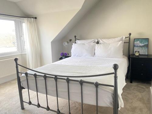 een slaapkamer met een bed met witte lakens en kussens bij Seaside Apartment in Ramsgate