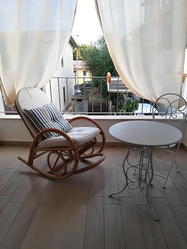 a balcony with a chair and a table and a window at LA BARCHETTA suite in Orosei