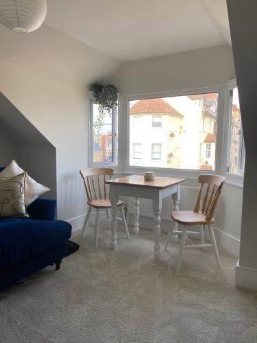 een eetkamer met een tafel en stoelen en een raam bij Seaside Apartment in Ramsgate