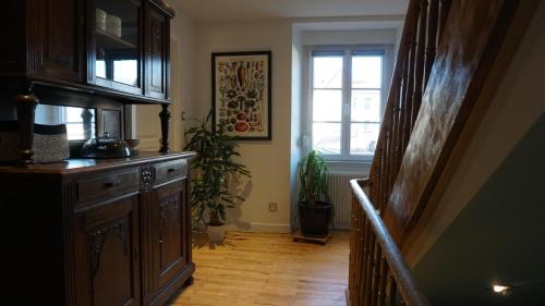 un couloir avec un plancher en bois et une fenêtre dans l'établissement La Maison Forestière, à Niederbronn-les-Bains