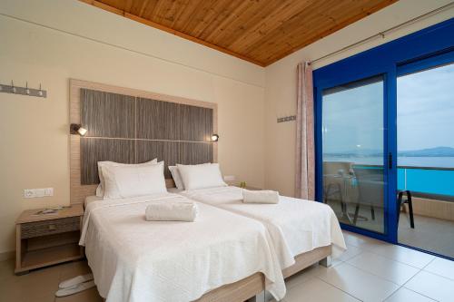 A bed or beds in a room at Minos Boutique Hotel