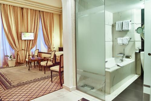 a bathroom with a shower and a dining room at Grand Hotel Continental Bucuresti in Bucharest