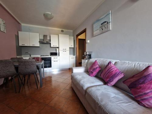- un salon avec un canapé et des oreillers roses dans l'établissement Home Gardaview Desenzano, à Desenzano del Garda