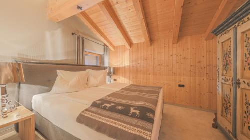 a bedroom with a bed in a wooden room at Chalet Lindau Fieberbrunn - by ONE VILLAS in Fieberbrunn