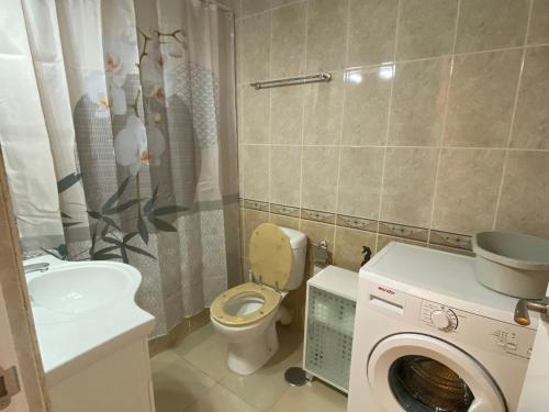 a bathroom with a toilet a sink and a washing machine at Studio Pinar in Sitio de Calahonda