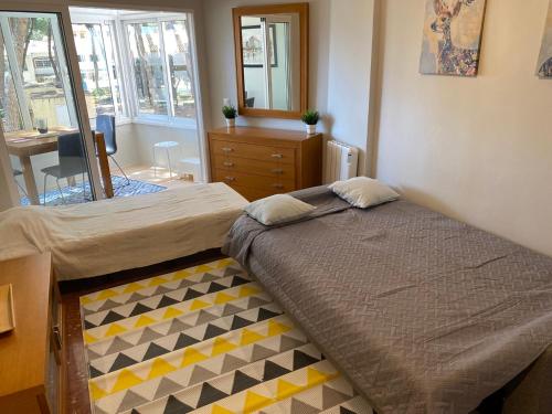 a bedroom with a bed and a dresser and a mirror at Studio Pinar in Sitio de Calahonda