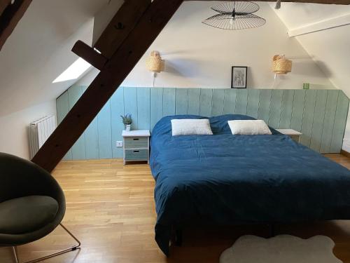 ein Schlafzimmer mit einem blauen Bett und einem Stuhl in der Unterkunft Chez Malouga 
