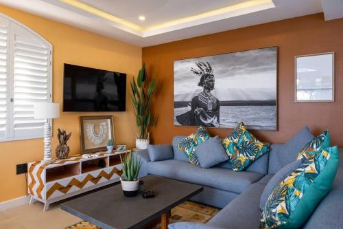 een woonkamer met een blauwe bank en een tafel bij Beachfront Luxury - 2 Chaka's Place in Ballito