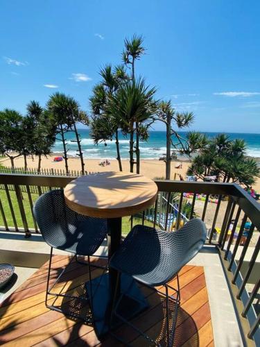a table and chairs on a balcony with the beach at Beachfront Luxury - 2 Chaka's Place in Ballito