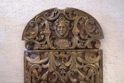 a wooden door with a face on a wall at De Merin Boutique Hotel Straden in Straden