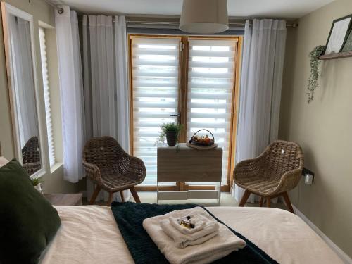 a bedroom with a bed and two chairs and a window at contemporary quiet countryside retreat in Horsley