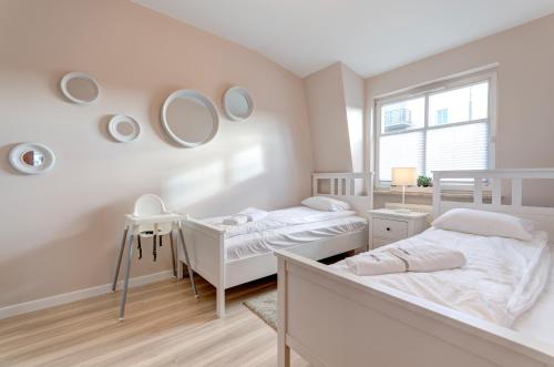 2 łóżka w białym pokoju z lustrami w obiekcie Dom & House - Apartments Parkur Sopot w mieście Sopot