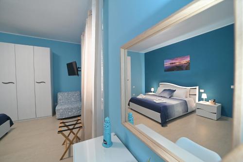 um quarto azul com uma cama e uma cadeira em Villa Borgo dei Pescatori em Torre Faro