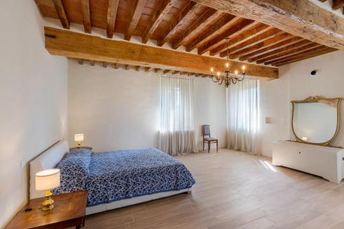 a bedroom with a blue bed and a mirror at Corte Croce in Gonzaga