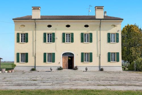 an old white house with green shutters at Corte Croce in Gonzaga