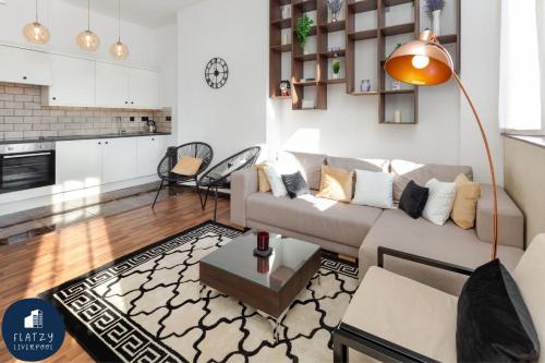 a living room with a couch and a table at FLATZY - Victoria Street Apartment - Heart of City Centre in Liverpool