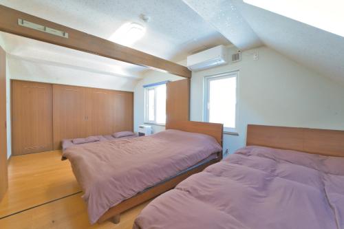 - une chambre avec 2 lits et une fenêtre dans l'établissement LAKE TOYA Great view log cabin, à Lac Tōya