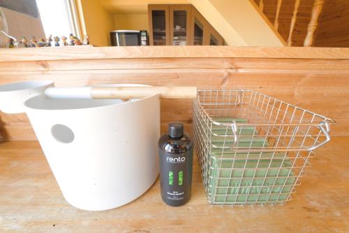 a bottle of alcohol next to a basket and a hair dryer at LAKE TOYA Great view log cabin in Lake Toya