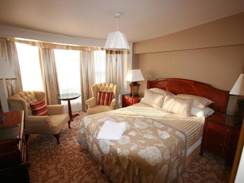 a hotel room with a bed and a desk and chairs at Colchester Boutique Hotel in Colchester