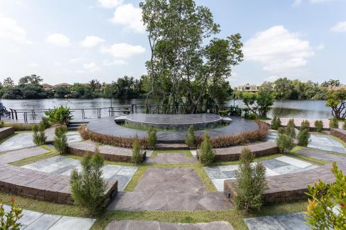 a garden with a bench and a pond at Laguna Grand Hotel & Spa Songkhla in Songkhla