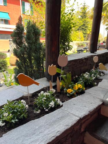 a garden with mushrooms and flowers on a wall at Garni degli Angioli in Ascona