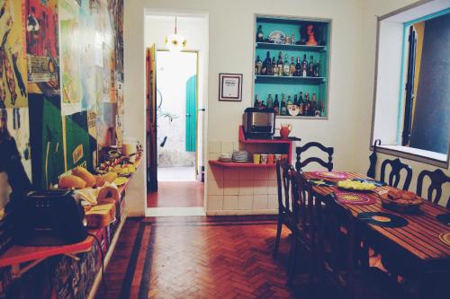 a dining room with a table and chairs and a kitchen at Mambembe Hostel in Rio de Janeiro